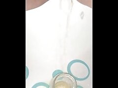 Creamy pussy pisses at a drinking glass